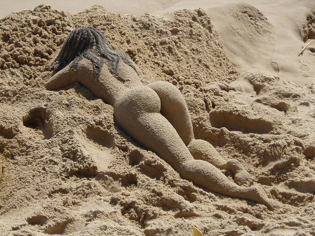 Нудистка соблазняет своей попкой на песке  15 фото эротики