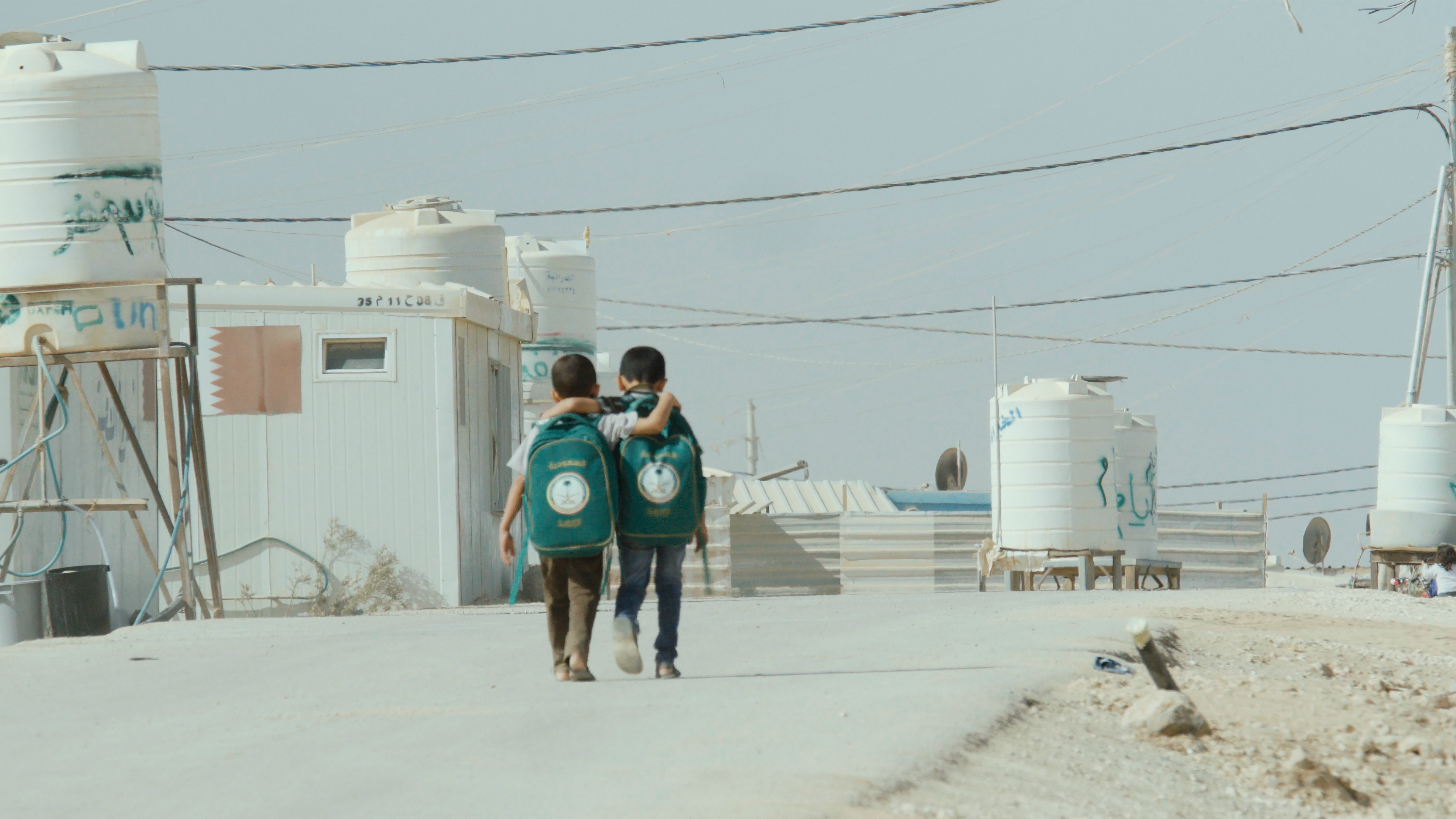 Two boys walking to/from school in a refugee camp