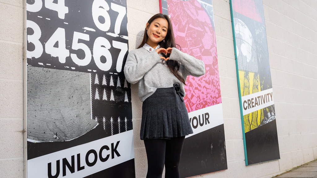 Tiffany posing in front of a creativity mural.