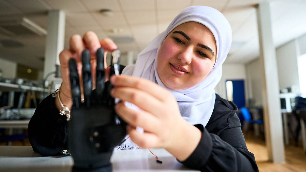 Leen attaches a sensor to a prosthetic hand in an electronic engineering lab.