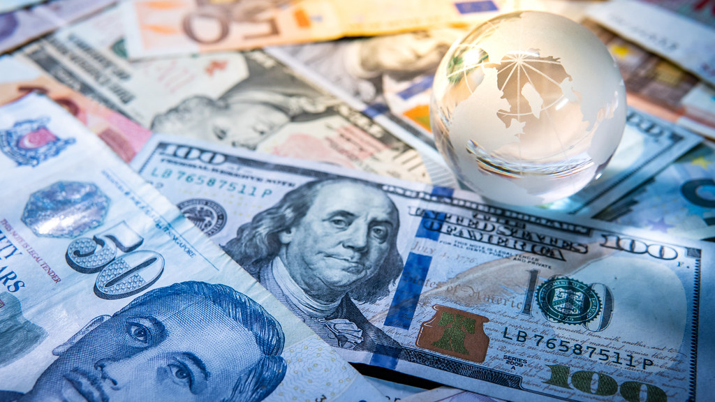 Image of money and a globe paperweight.