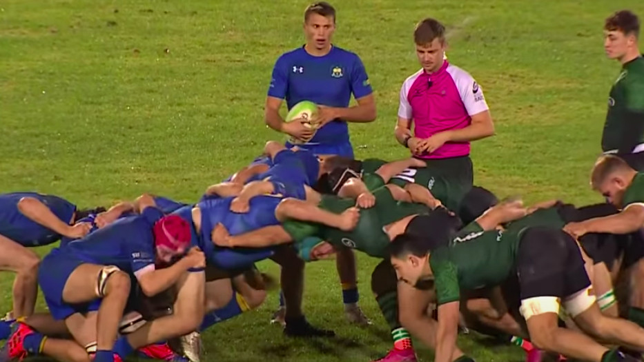 Two opposing rugby teams taking part in a scrum during a match.