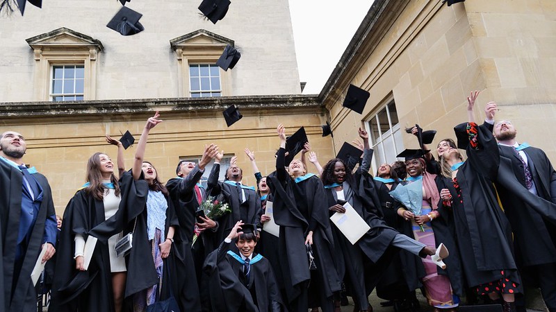 即将毕业的学生将他们的帽子抛向空中以示庆祝.