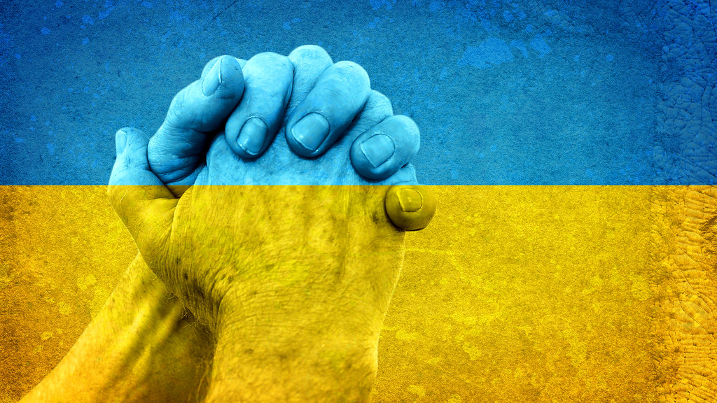 双手合十，上面覆盖着乌克兰国旗. 