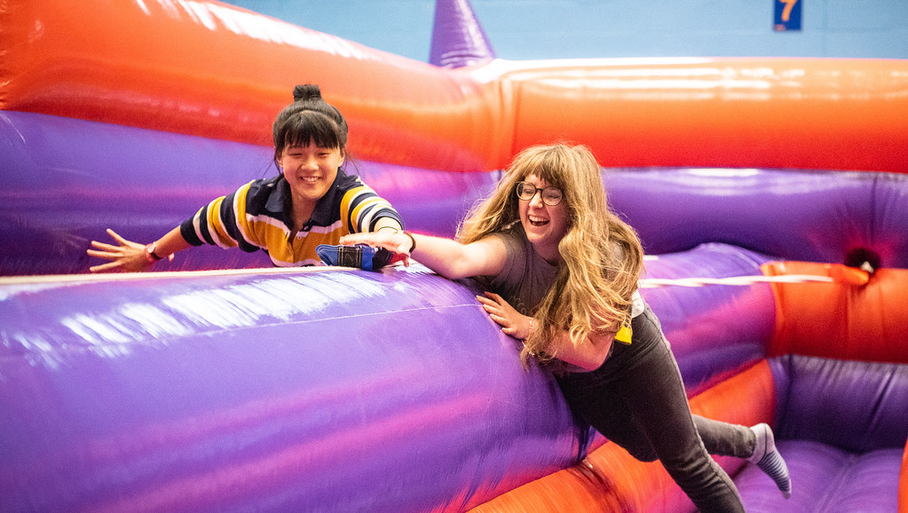 Two students on an inflatable bungee-run game