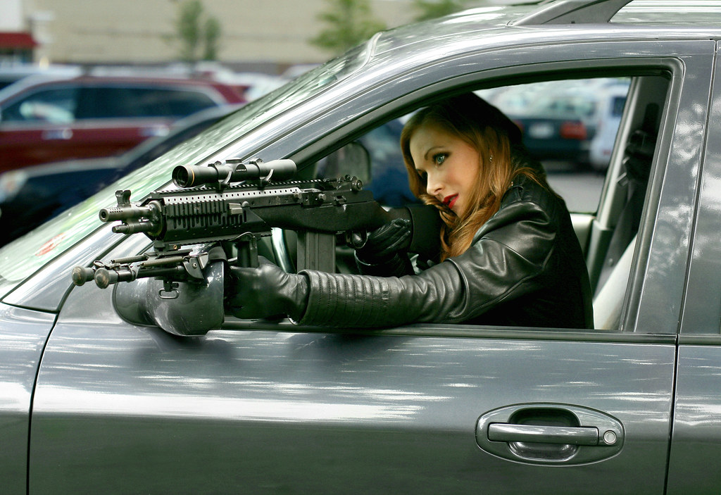 Фото мулатки в кожаном белье и с оружием в руках на автомобиле