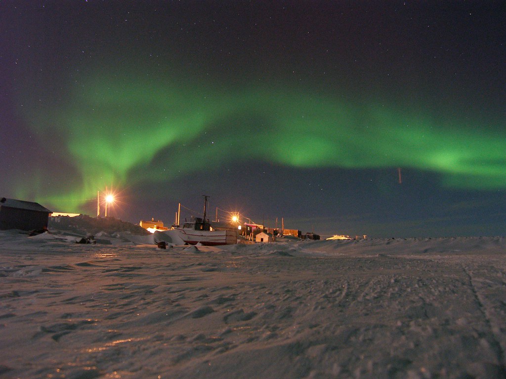 Nornthern lights over a snowy landscape.
