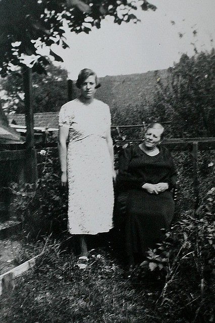 Moeder met Opoe in de tuin achter hun huis.