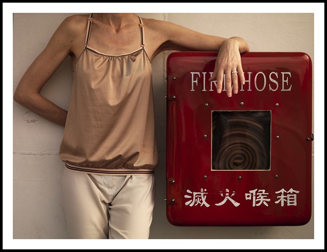 Woman leaning on a fire hose box, Hong Kong, China
