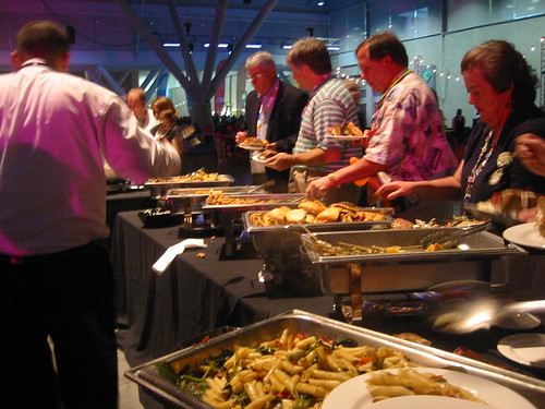 Personas cogiendo comida la barra de un buffet libre