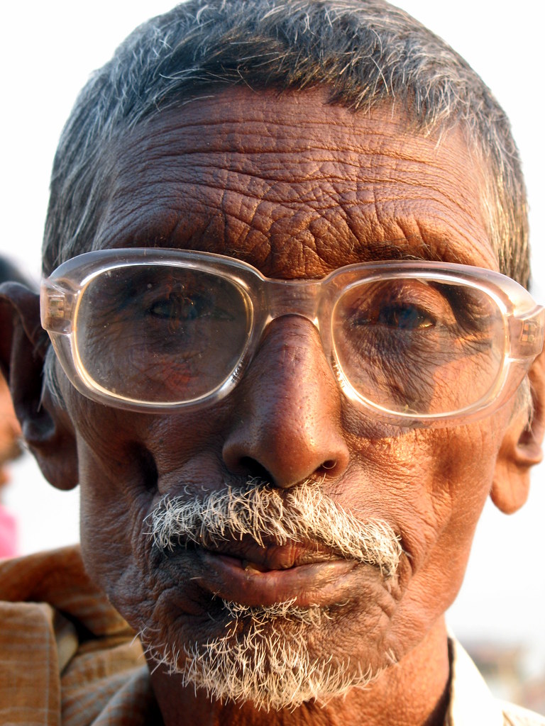 An old man wearing glasses, having all his hair and a furr… | Flickr