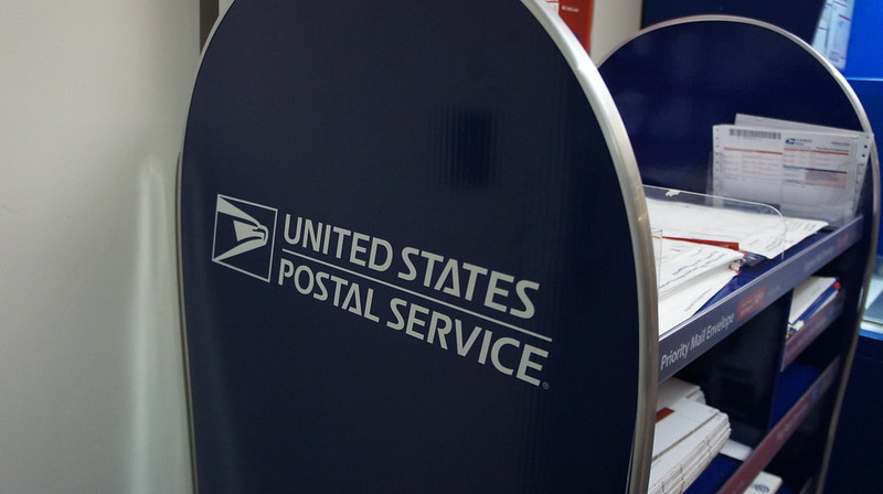 USPS logo on packaging display, APC in background