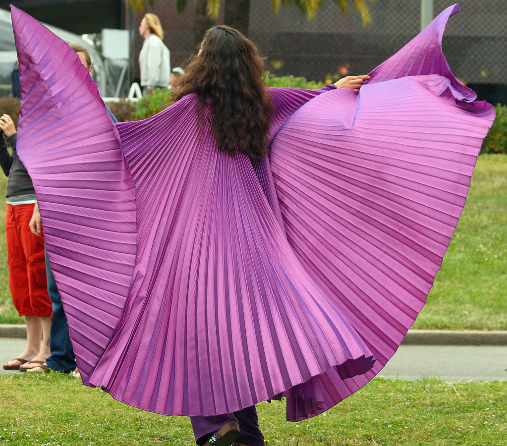 Nikki Nez twirling in purple at a God is Love gathering in SF's Golden Gate Park
