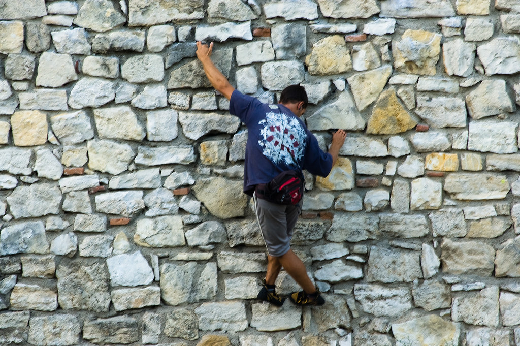 A man is free climbing a rock wall
