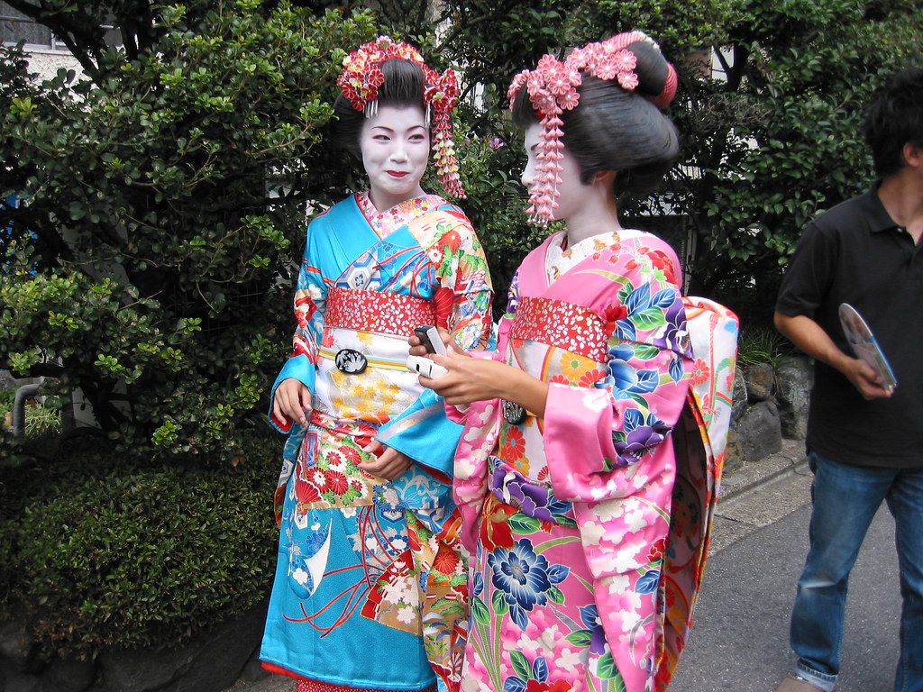 A geisha and a maiko share a joke, Kyoto, Japan