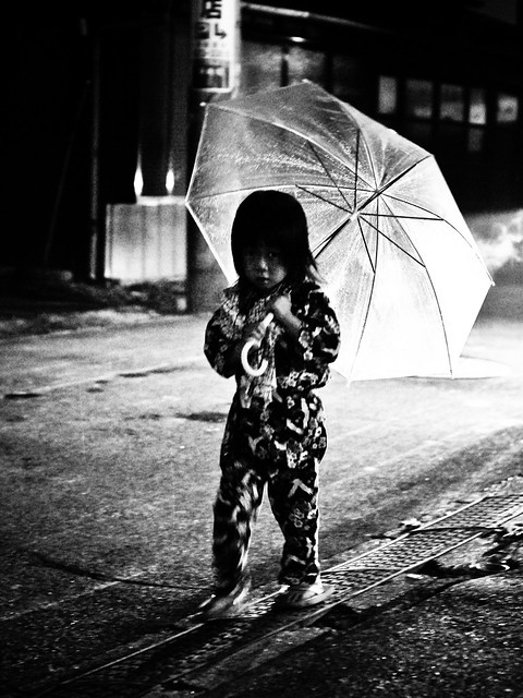 Little girl with an umbrella in the rain