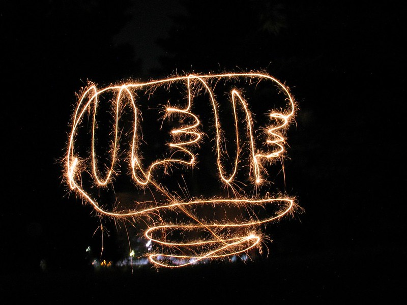 Amber sparkler flame swirled to spell a word, possibly MEME?