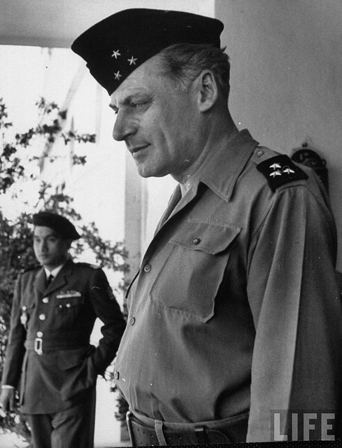 Hanoi, March 1954 - Gen. Rene Cogny, French Army commander, face very serious and rather sad, as he futifully walks behind the absentee playboy ruler of Annam, Bao Dai