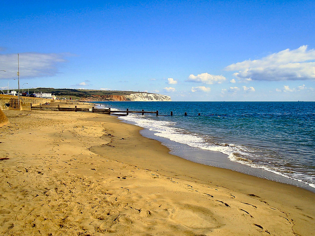 Sandy beach with a pier and blue sea