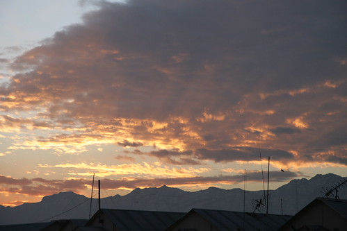 Waking Sun by Michael S Palmer, The sun prepares to peak over the mountains, coloring the clouds with a gentle pink and orange tint.