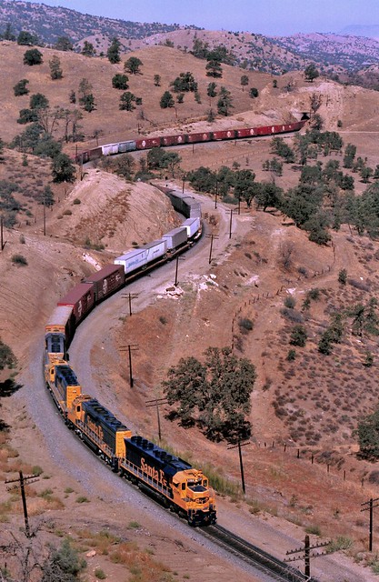 Santa Fe Railway SD-45 locomotive number 5308, plus an SD-45-2, an SD-40-2 and another SD-45, leads an eastbound freight train through Tehachapi Pass on trackage shared with and owned by the Southern Pacific. Kern County, California, July 15, 1985.