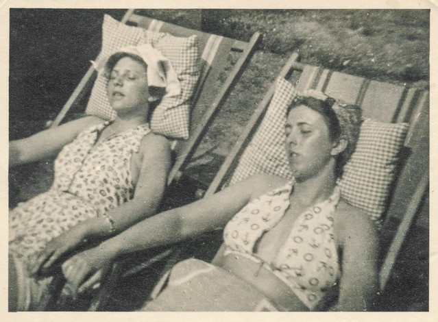 Two women sleeping on lawn chairs