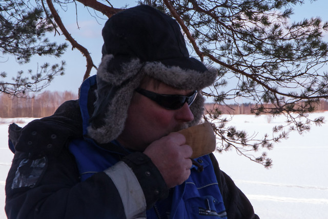 man taking a sip from the wooden coffee cup