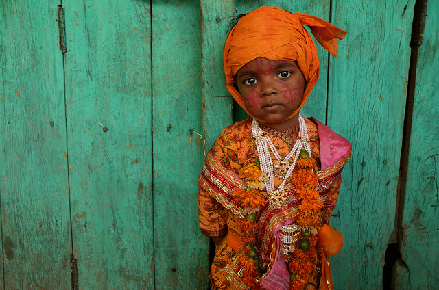 Child with colorful face decorations and traditional dress  during nangdaon holi celebrations, India