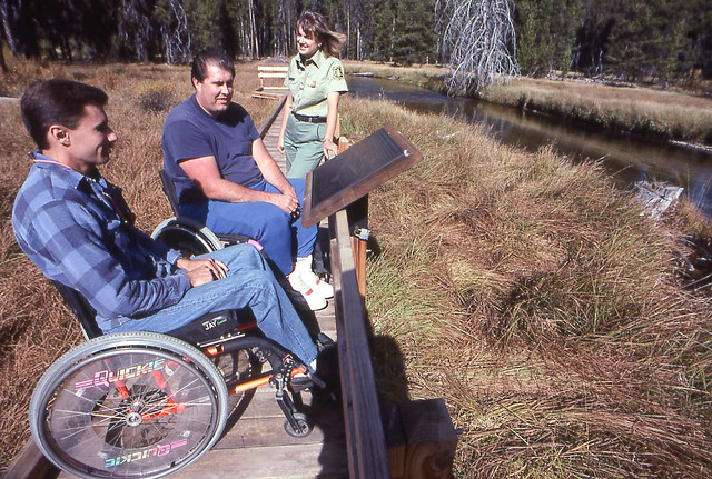 Men in Wheelchairs at Interpretive Sign with Female Ranger