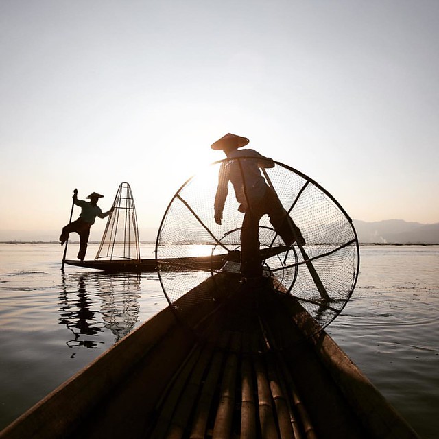 Captured in December 2015, fishermen at inle lake, Myanmar. Local fishermen are known for practicing a distinctive rowing style which involves standing at the stern on one leg and wrapping the other leg around the oar. This unique style evolved for the re
