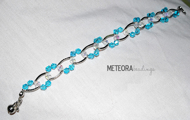 Bracelet - baby blue and clear beads, with silver spacers and bell