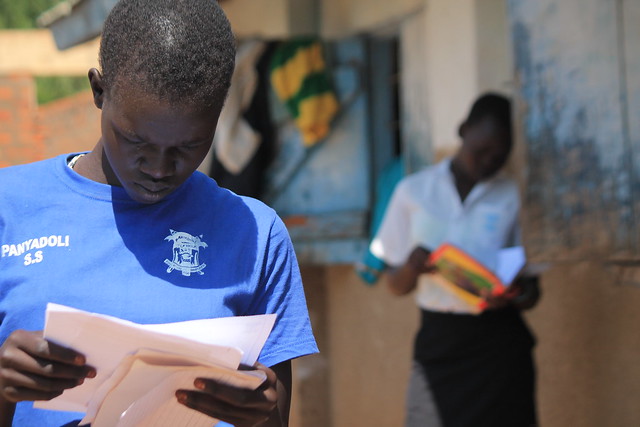 Students look at their report cards. Uganda