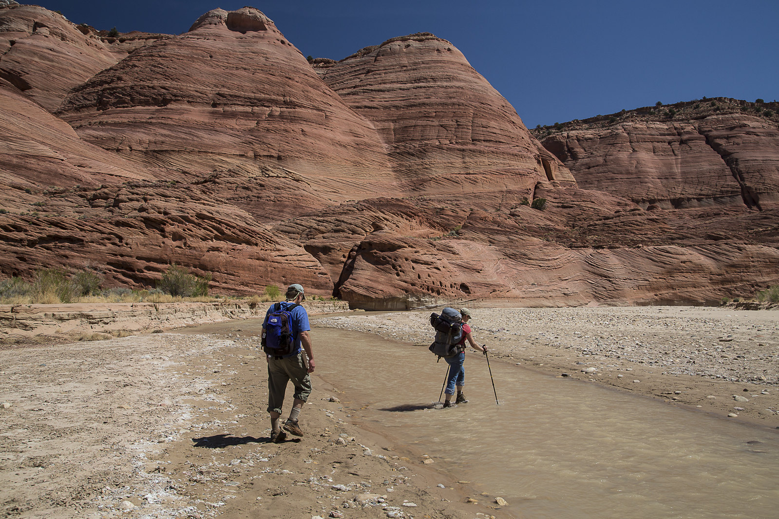 Two people hike Vermilion Cliffs National Monument