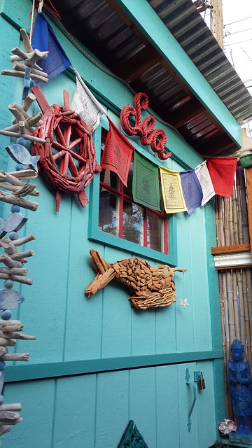Decorations, A Garden for the Buddha, bike shed, Sea, Tibetan Buddhist prayer flags, Dharma wheel, whale, star fish, fish, statue of person praying, turquoise, red, blue, white, green, yellow, dark blue, bamboo fence, Seattle, Washington, USA