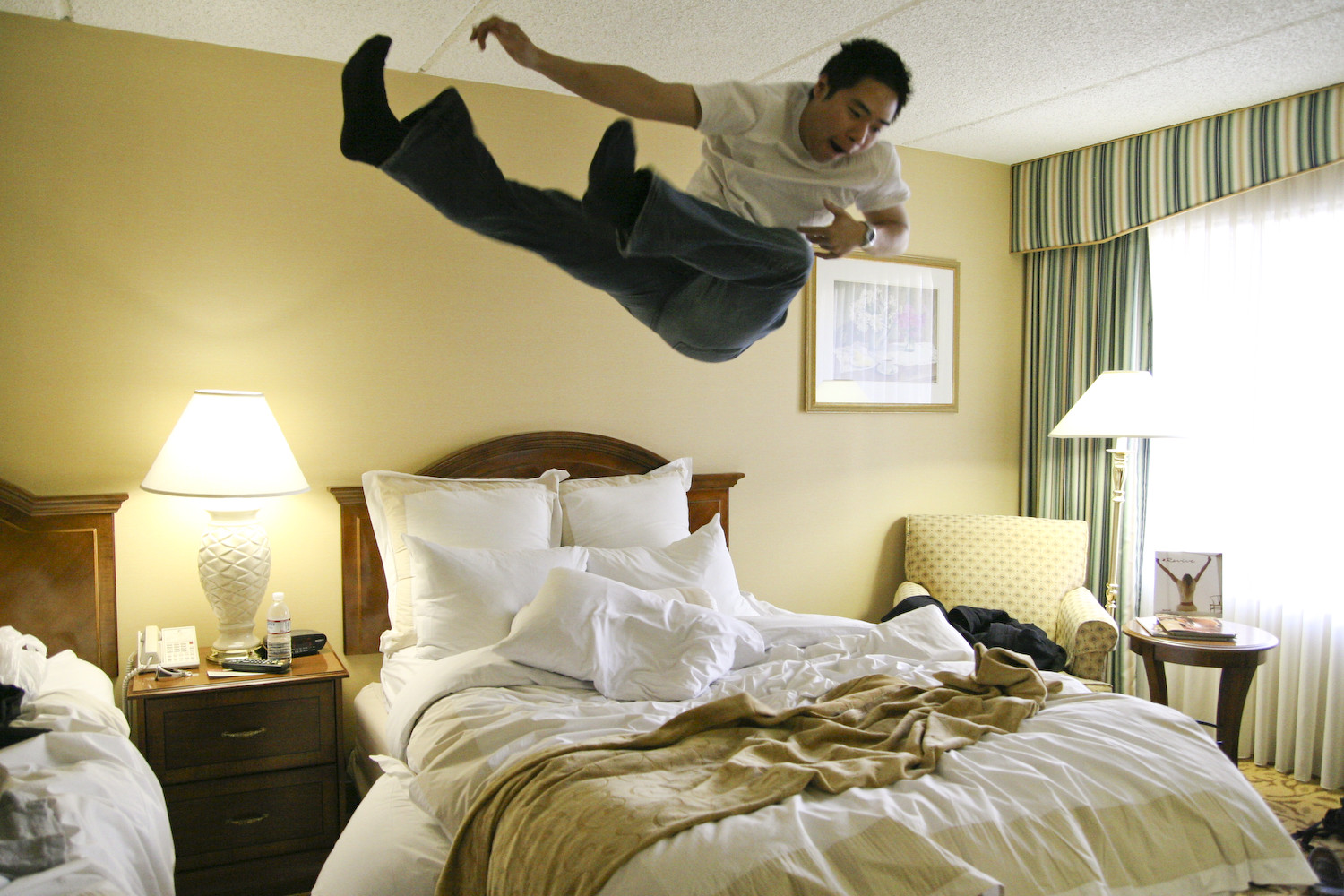 Bed falling. Прыгать на кровати. Человек прыгает на кровати. Прыгать на кровати в отеле. Подпрыгнуть на кровати.