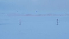 Near blizzard conditions -- Racing sleds -- Snowmobile racing and show on Houghton Lake, Michigan
