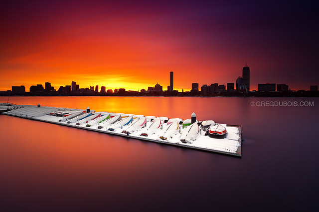 Boston Skyline Sunrise over Charles River and Snow Covered Boats from Cambridge Massachusetts USA