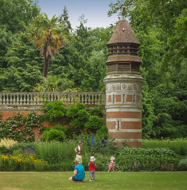 A family relaxes by the Dovecot Tower in the gardens of Cliveden House in Berkshire