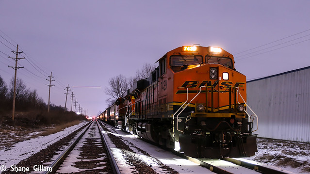 BNSF 7439 sit's quietly while a passenger plane races over head.