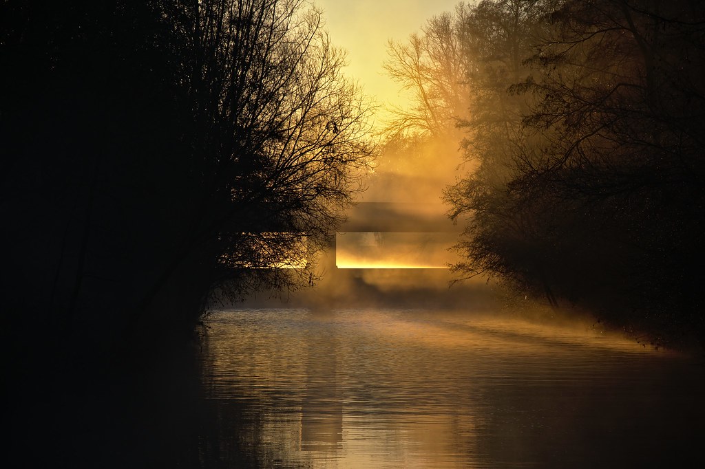 Weir in sunrise mist