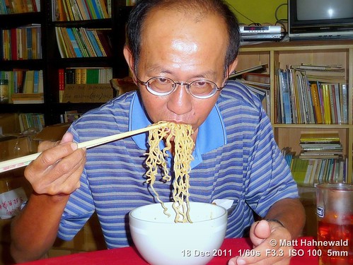 noodles eating food travel eyeglasses ethnic portrait cultural character authentic indoor street eyes traditional asia asian flash matthahnewaldphotography face facingtheworld chopsticks horizontal head kuah langkawi malaysia malaysianchinese southeastasia tuckinginto munching devouring bowl ramen restaurant lunch soup background buddhism vegetarian panasoniclumixdmctz5 halflength story chomping fullfaceview 1200x900pixels resized colour colourful person 4x3ratio chewing emotional closeup consensual health lookingatcamera