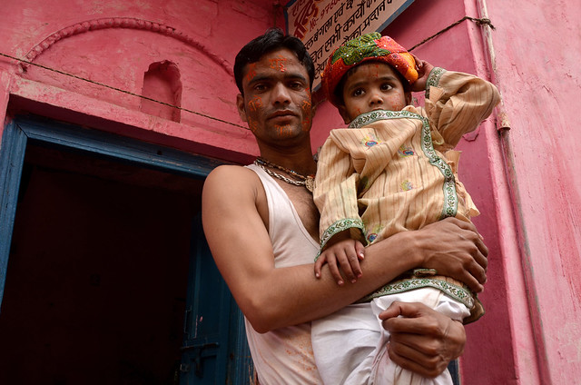 Father and son with colorful holi decoration, barsana, India