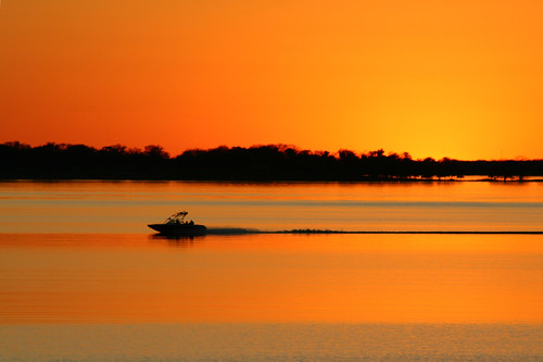 sunset orange color boat texas dam lakesomerville
