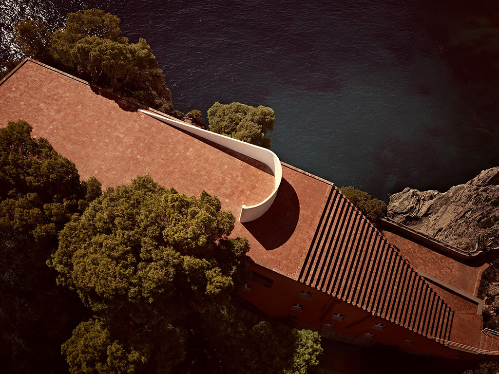 Casa Malaparte, Adalberto Libera. 1963: A brown colored structure with stairs along the right side. 