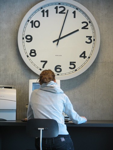 Woman and big clock at Roskilde University Library