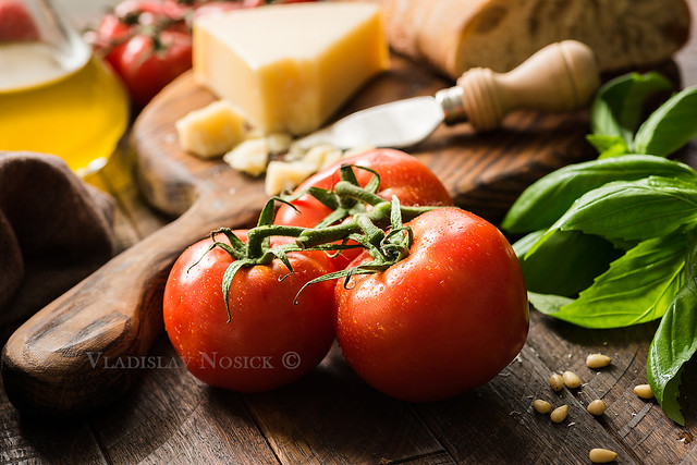 Tomatoes on vine, olive oil and parmesan cheese, food background