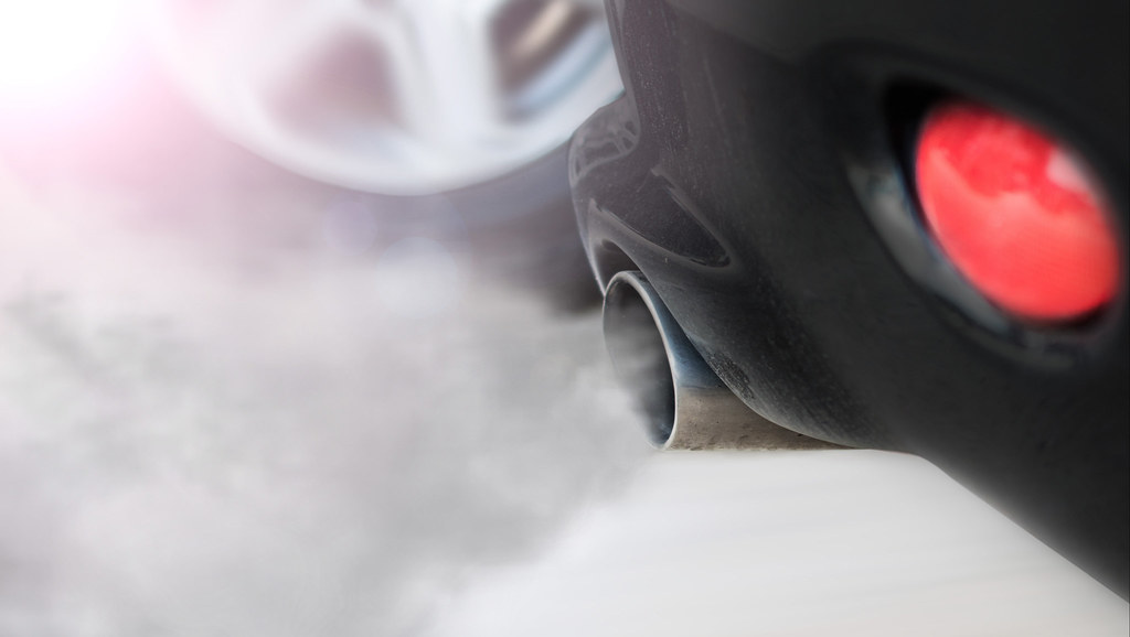 A close-up of a car exhaust emitting clouds of air pollution