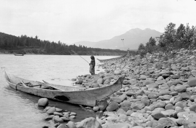 Girl fishing in the Skeena River beside a dugout cedar canoe, Kitwanga (Gitwangak/Gitwangax), British Columbia / Jeune fille pêchant dans le fleuve Skeena près d’une pirogue en cèdre à Kitwanga (Gitwangak/Gitwangax) (Colombie-Britannique)