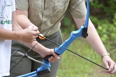 photo of ranger helping visitor with archery