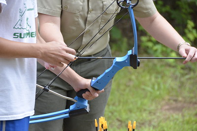 photo of ranger helping person with bow and arrow